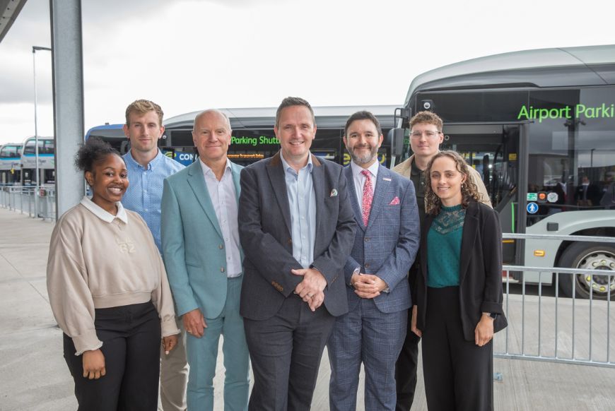 7 people posing outside of  bristol airport